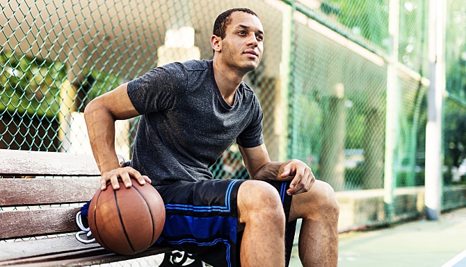 Man sitting on a bench with a basketball